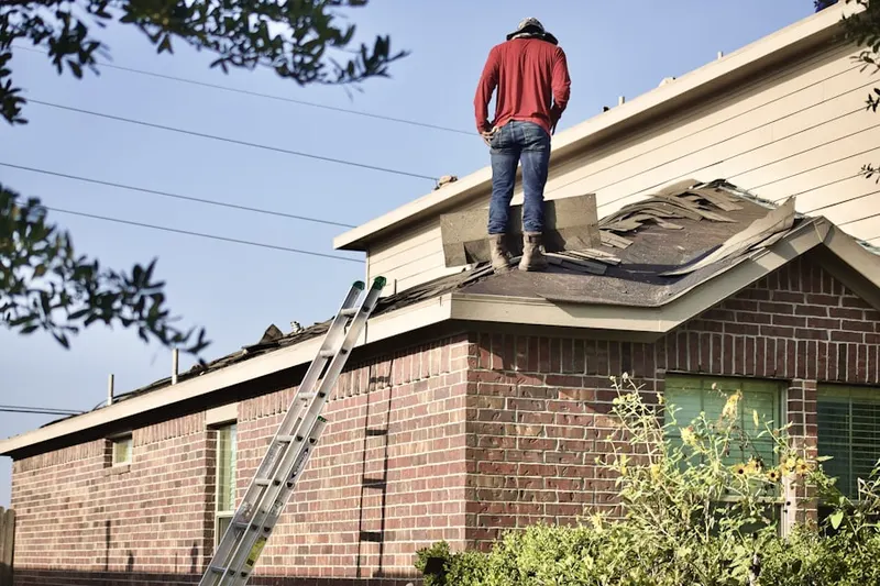 Professional roofer working on a residential roof in Harrisonville